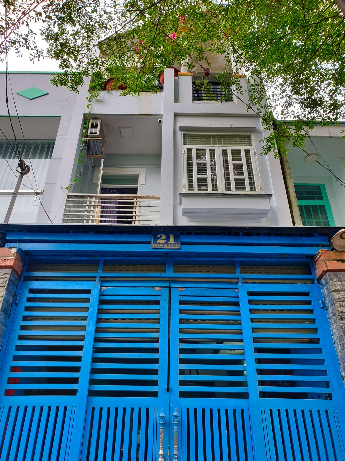Mặt tiền nhà phố 3 tầng, cổng sắt xanh, ban công có cây, KDC Phú Lợi Quận 8